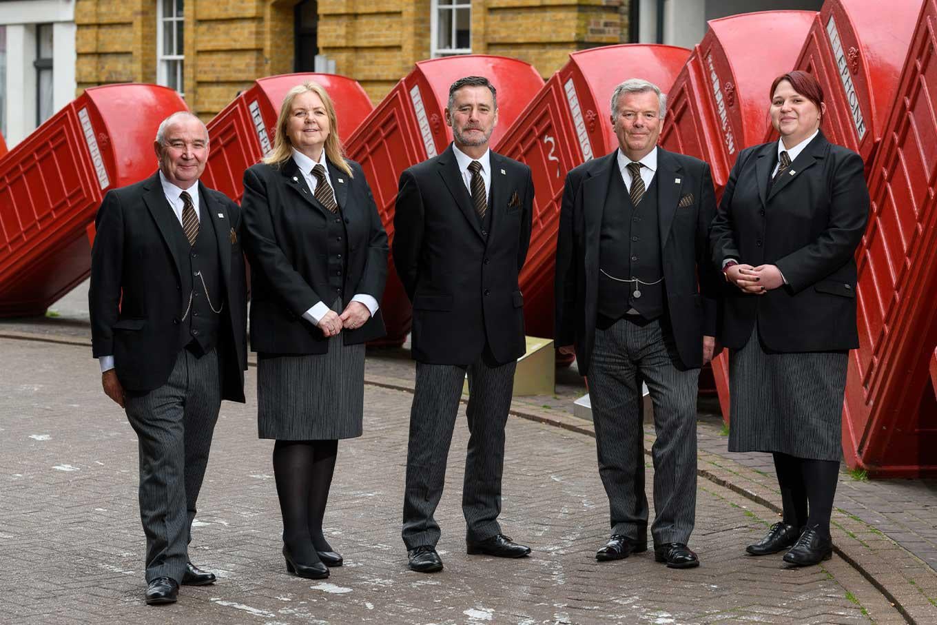 Frederick-W-Paine-funeral-directors-stand-outside-their-London-Road-funeral-home-in-front-of-red-phone-boxes